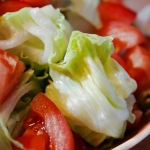 A plate of iceberg salad and tomatoes.